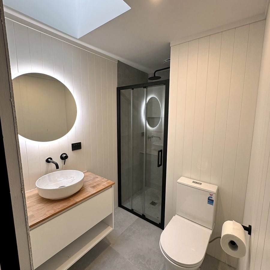 Bathroom renovation with timber vanity and round mirror